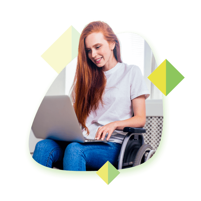 Women with long red hair using a laptop while sat in a wheelchair.